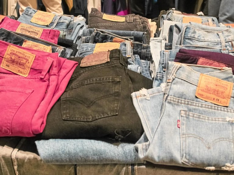 Jeans venduti in un mercato di seconda mano, Milano, ottobre 2018. - Alamy